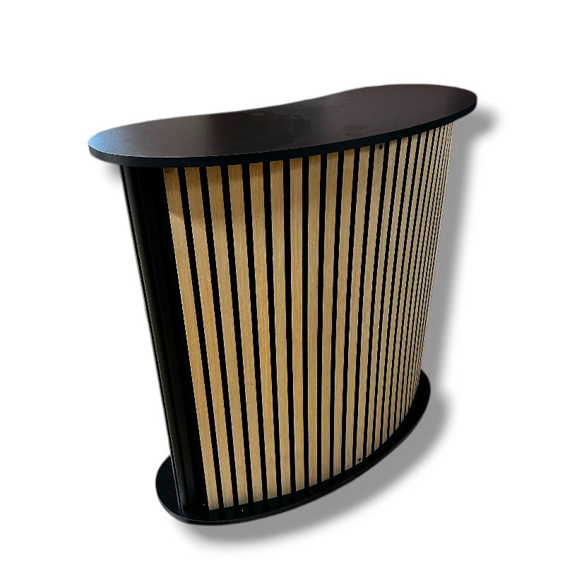 Beygður diskur með hillu. Framhlið með hljóðdeyfir / viðarlamellum. B104 x D43 x H105 cm.