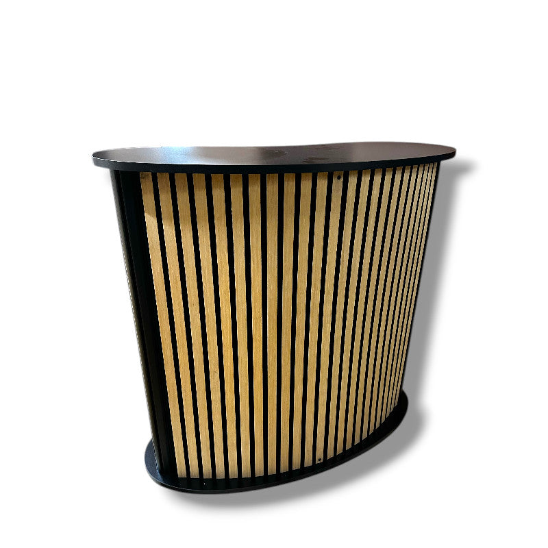 Beygður diskur með hillu. Framhlið með hljóðdeyfir / viðarlamellum. B104 x D43 x H105 cm.