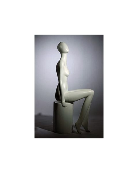 Dömugína. Með höfuð án andlitsdrátta. Hvít mött. Lúffuhendur. Sitjandi