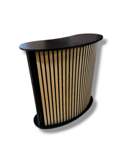 Bogadregið afgreiðsluborð með hillu. Framhlið með hljóðeinangrunar plötum/viðarlistum. B104 x D43 x H105 cm.